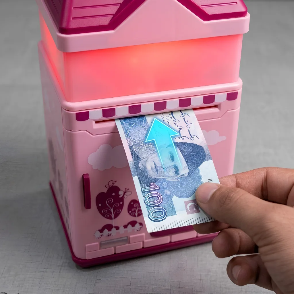 Hand inserting a 100-rupee note into the ATM piggy bank's automatic banknote pull system